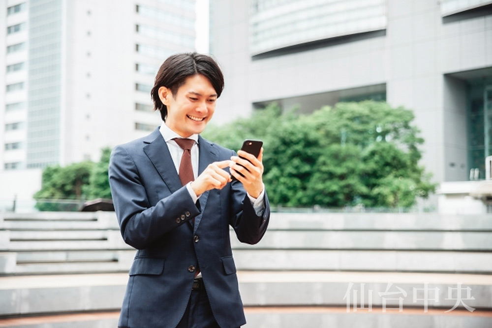 陰茎の曲りに関しスマホで検索する男性