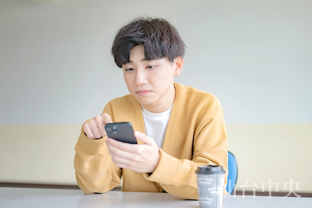 包皮と亀頭の癒着をスマホで検索する男性